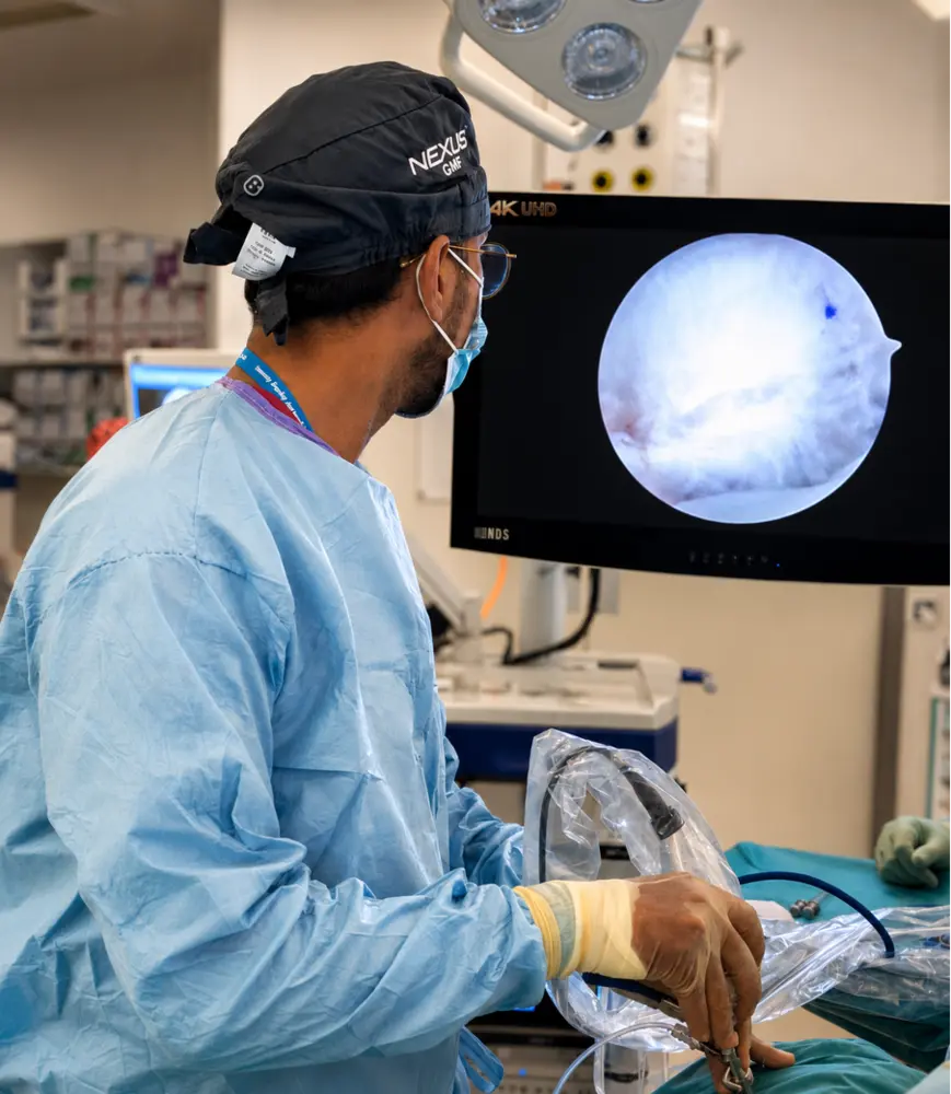 Mr Kohmal Solanki performing TMJ arthroscopy, with the joint shown on the theatre monitor